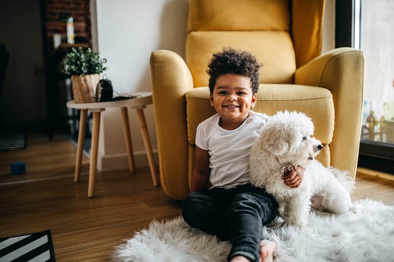 Boy hugging dog in living room