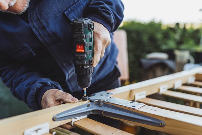 Man drilling a screw into wood